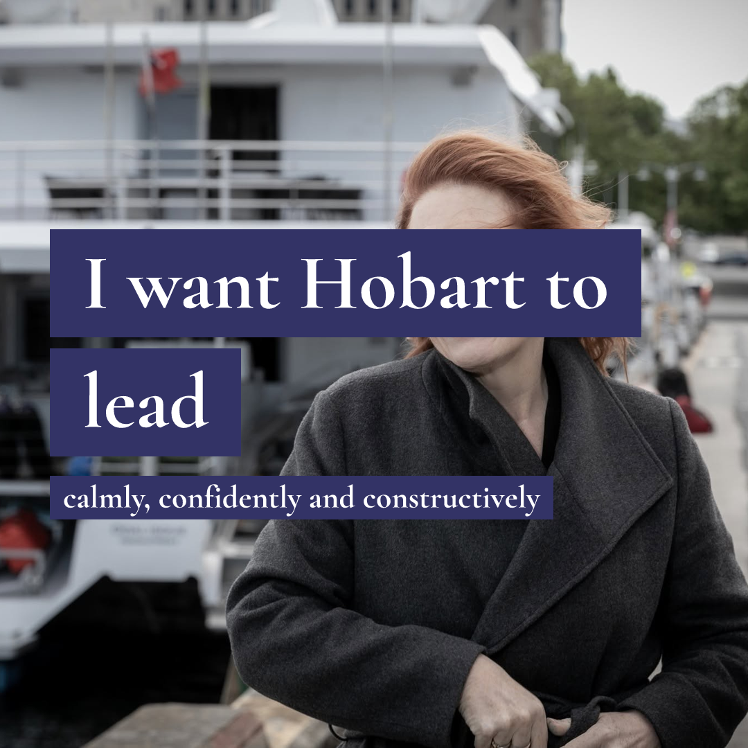 A woman in a grey coat stands before a boat with text: I want Hobart to lead calmly, confidently and constructively.