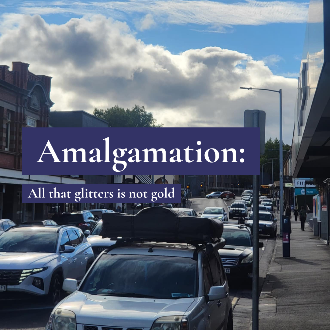 Traffic on a city street under a cloudy sky with text 'Amalgamation: All that glitters is not gold' overlaid.