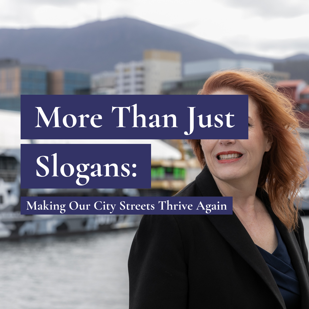 A smiling woman with red hair in a dark coat on the Hobart waterfront with text: More Than Just Slogans: Making Our City Streets Thrive Again.